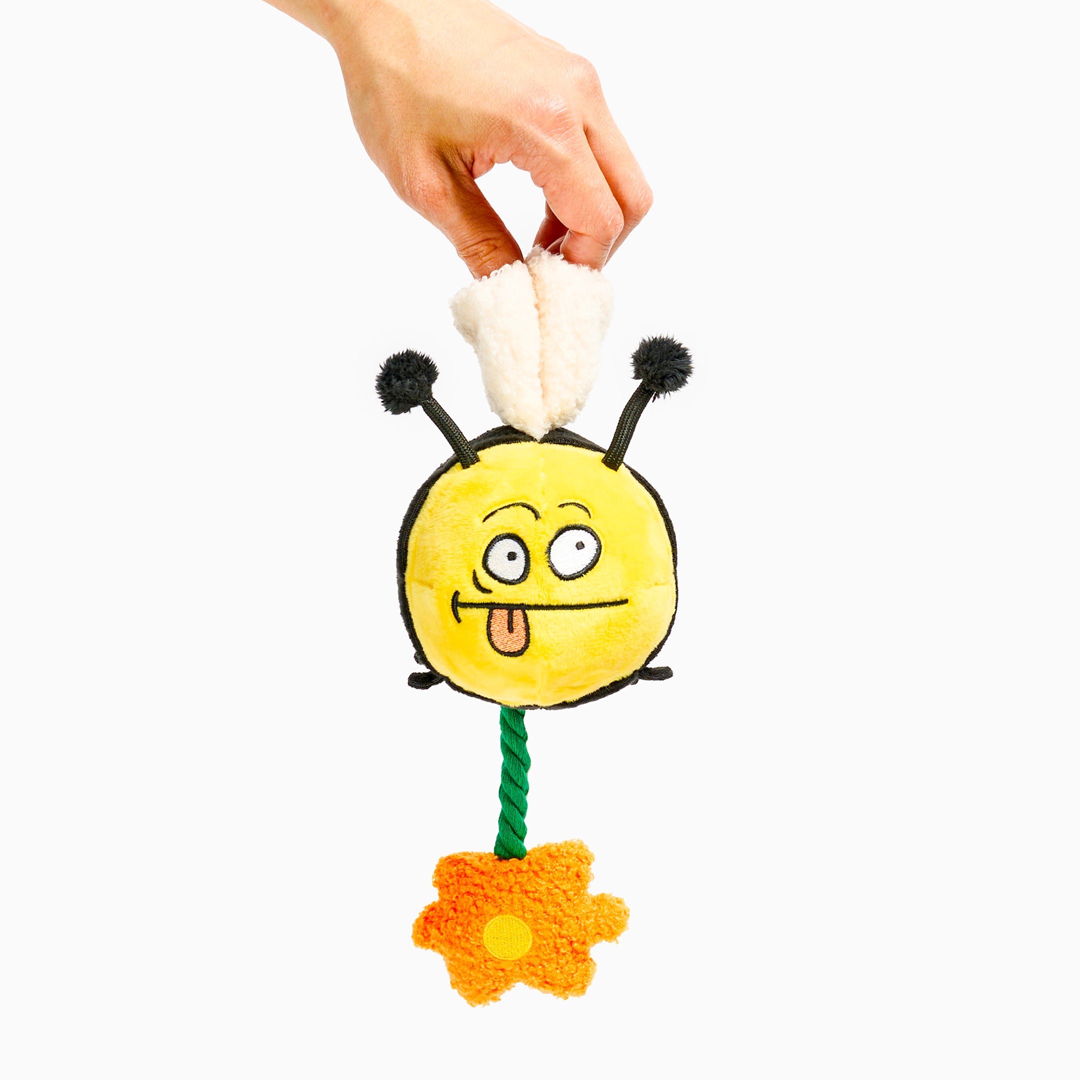 Toy bee with a hand holding it on a white background