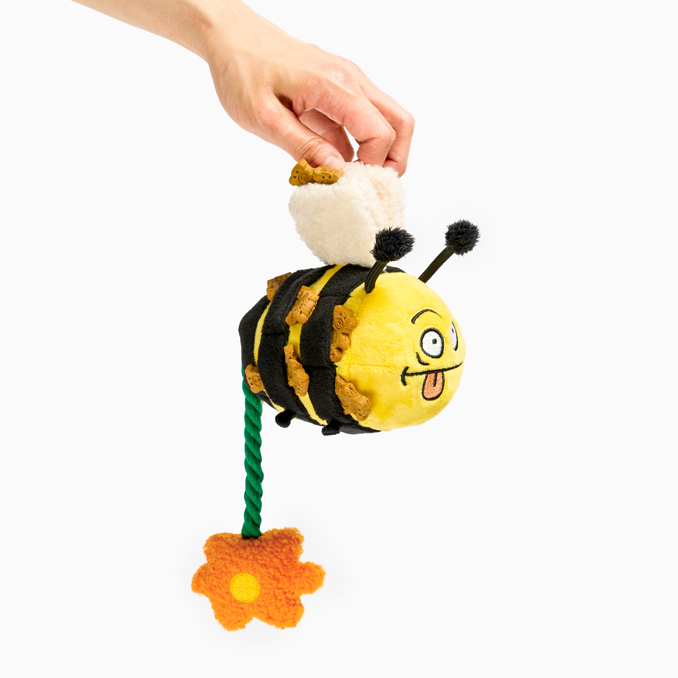 Plush bee toy with a hand holding it on a white background