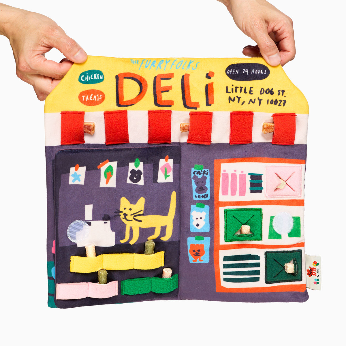 Deli Nosework mat with its door flap open, showing treats tucked into colorful fabric loops and pockets beneath a yellow DELI sign.