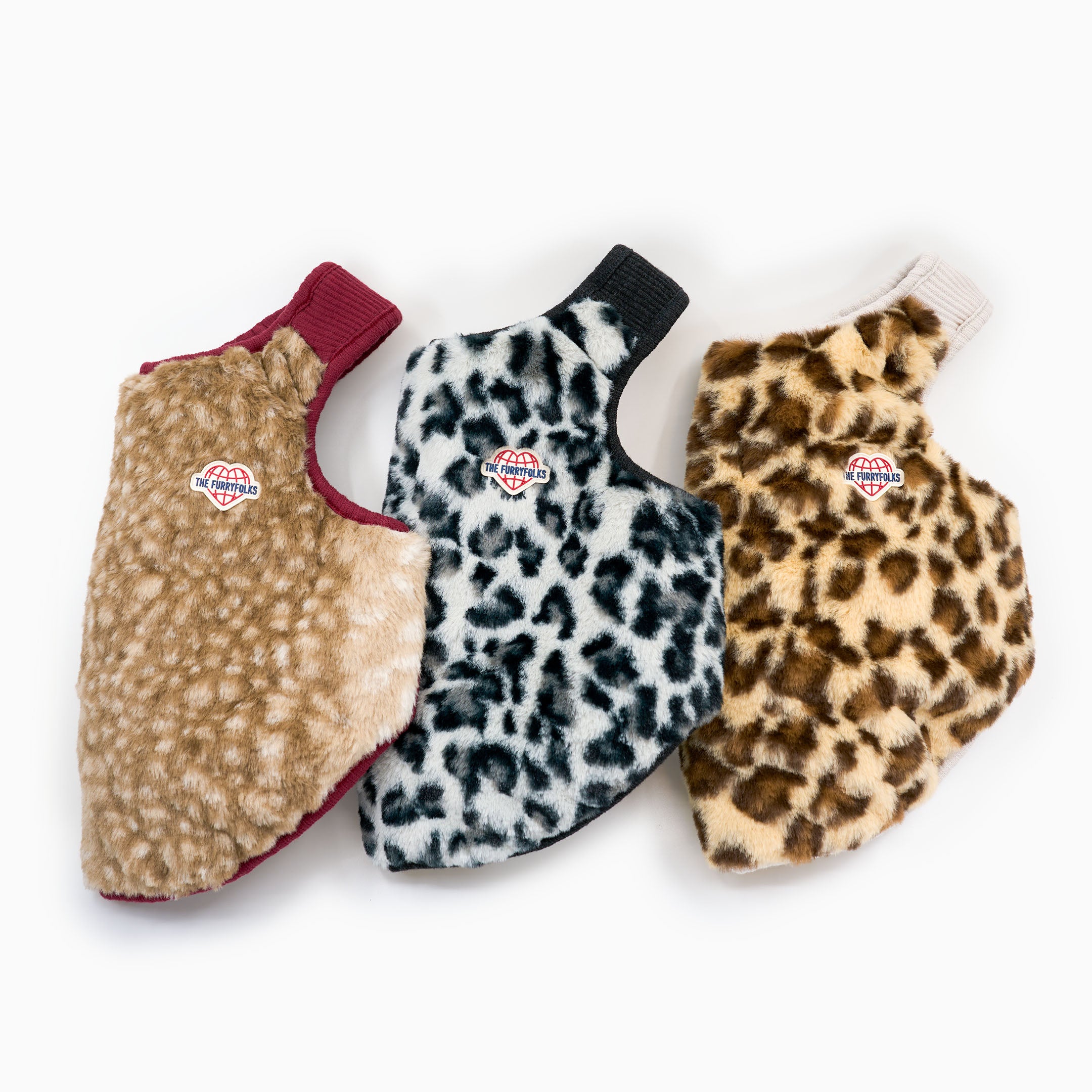 Three fur-patterned dog coats with different designs on a white background