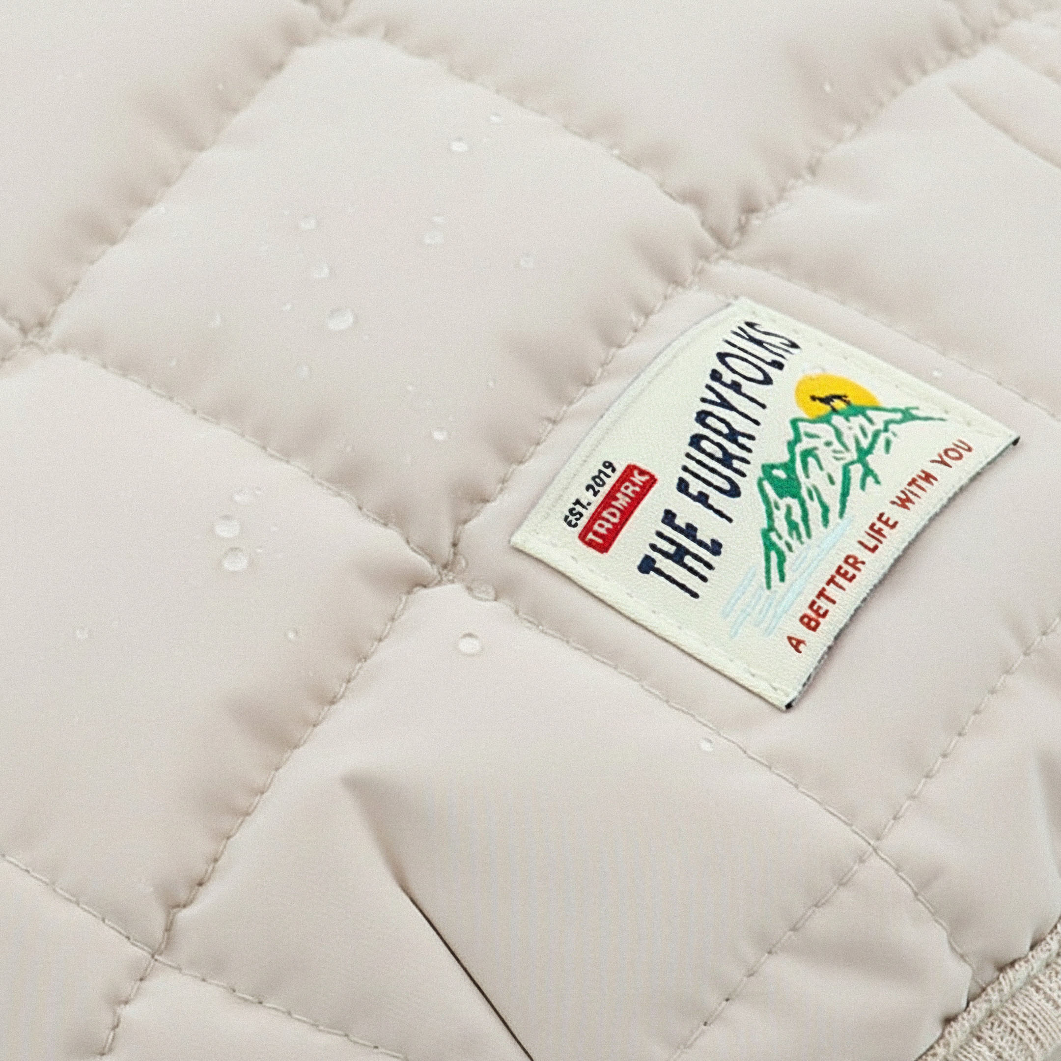 Close-up of a quilted fabric surface with a brand label on it.