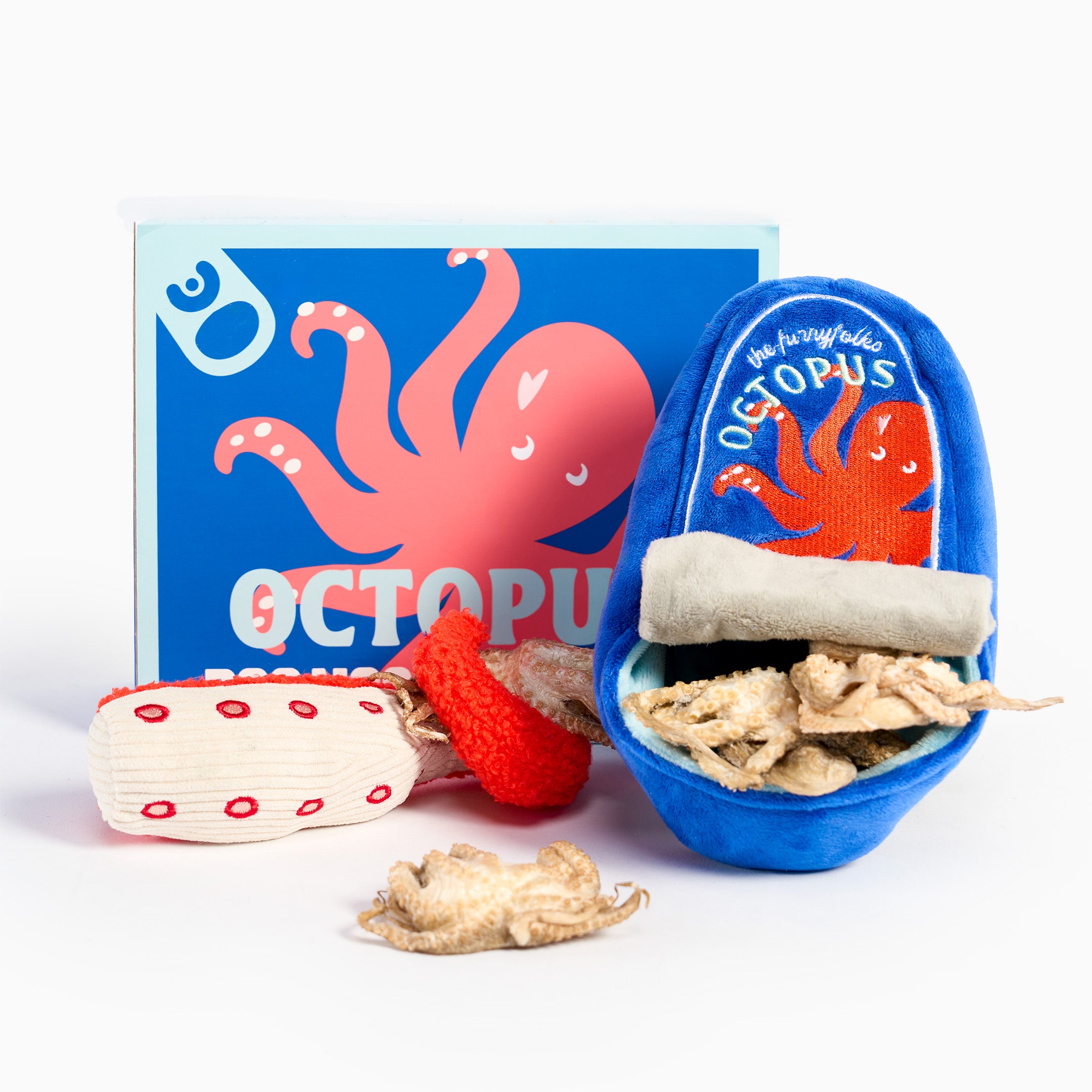 Octopus-themed pet toy set on a white background, including a blue plush octopus-shaped container with treats inside, a red textured toy, a cream-and-red striped toy, and a blue box with an octopus illustration.