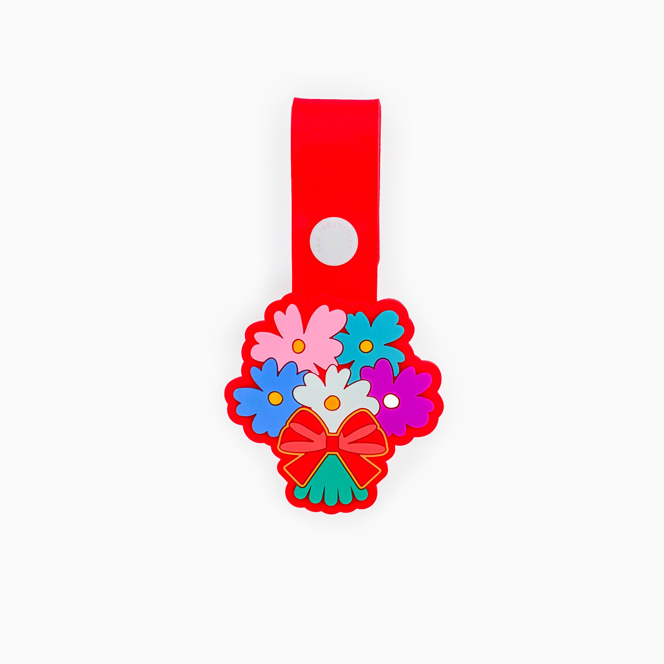 A red dog tag in the shape of a colorful bouquet of flowers. The tag features a variety of flowers in vibrant colors and is made of non-toxic rubber. It has a loop for attaching to a collar or harness, showcasing a cheerful and decorative design.